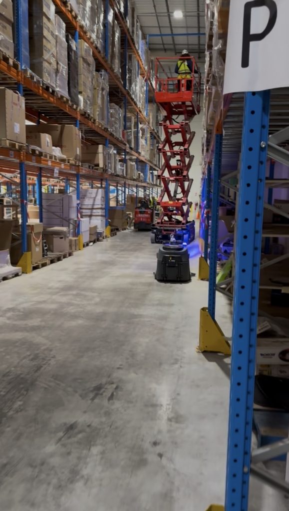 Robot de nettoyage autonome en entrepôt logistique en fonctionnement dans un environnement industriel