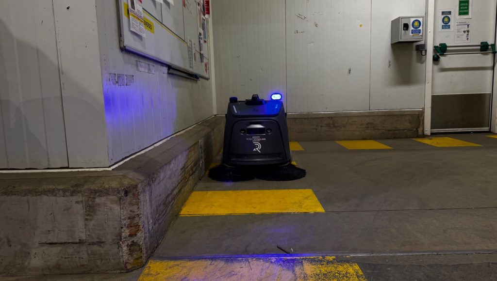 Robot de nettoyage autonome RobotDynalink en intervention dans un entrepôt logistique avec logo visible